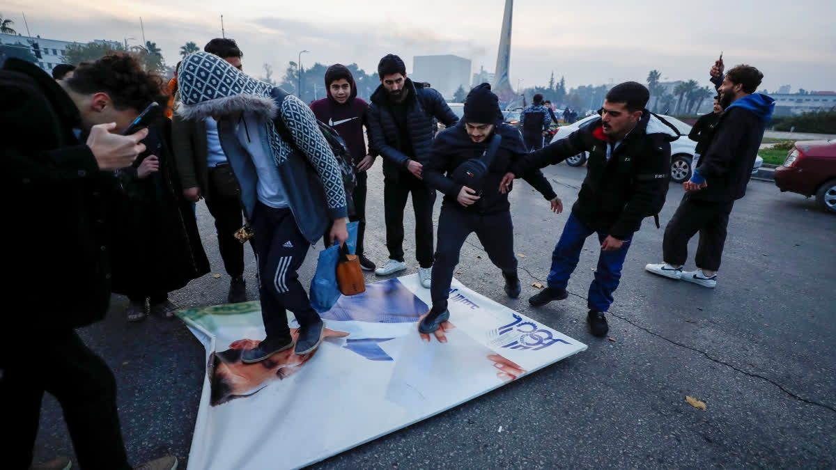 Syrians celebrate the arrival of opposition fighters as they step on a picture of Syrian President Bashar Assad in Damascus, Syria, Sunday, Dec. 8, 2024. (AP Photo) author img